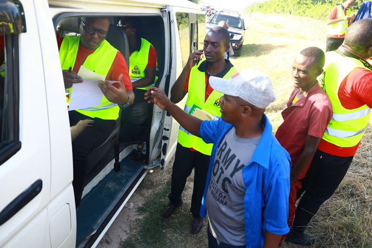 KFCB's Victor Okello issues a license to matatu driver Wycliff Osiemo at Bamburi Mtambo in Mombasa during a crackdown on Monday.