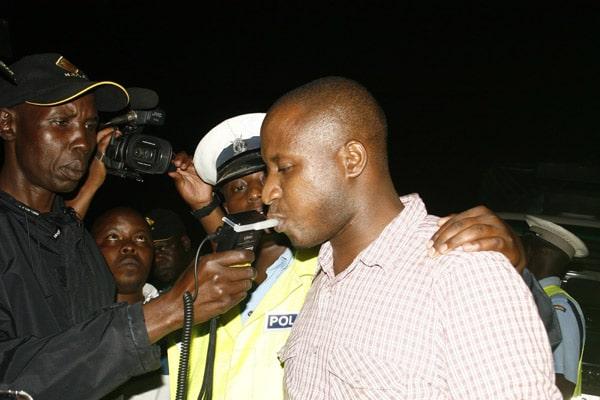 Police officers issue a breathalyzer test to a motorist in Kisumu.