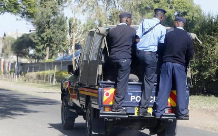 Police hanging on a van. A passenger was allegedly pushed out of a speeding matatu a few meters from Kakamega Police Headquarters