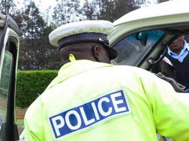 A traffic police officer inspects a matatu. 38 NTSA cars handed over to police to go to traffic department - Inspector General Hillary Mutyambai